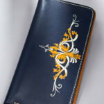 Designer leather wallet gift with golden abstract swirls on dark blue leather